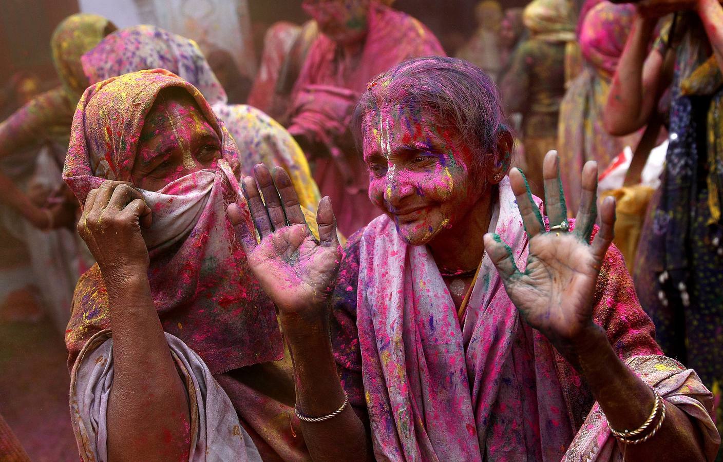 Mujeres viudas de Vrindavan pintarrajeadas en colores toman parte en las celebraciones de Holi, organizado por la organización no gubernamental Sulabh Internacional. Fotografía: EFE / Harish Tyagi