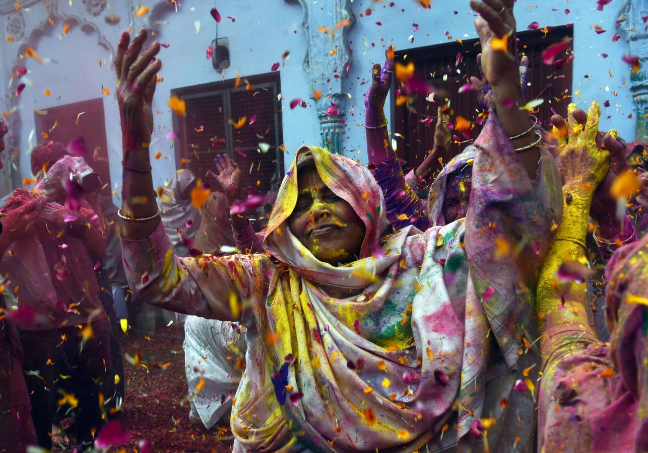 Mujeres viudas de Vrindavan pintarrajeadas en colores toman parte en las celebraciones de Holi, organizado por la organización no gubernamental Sulabh Internacional. Fotografía: AFP / Roberto Schmidt