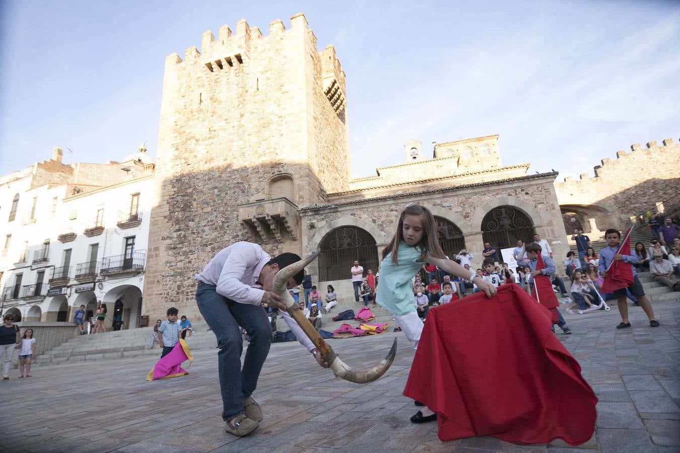 Jueves, 14 de mayo: El matador de toros cacereño Manolo Bejarano dirigió en la Plaza Mayor de Cáceres, una clase práctica de toreo de salón en la que participaron decenas de niños que, asidos a sus muletas y capotes, deleitaron a cuantos se acomodaron en las escaleras del Arco de la Estrella para contemplar tan inusual estampa. Fotografías: Jorge Rey