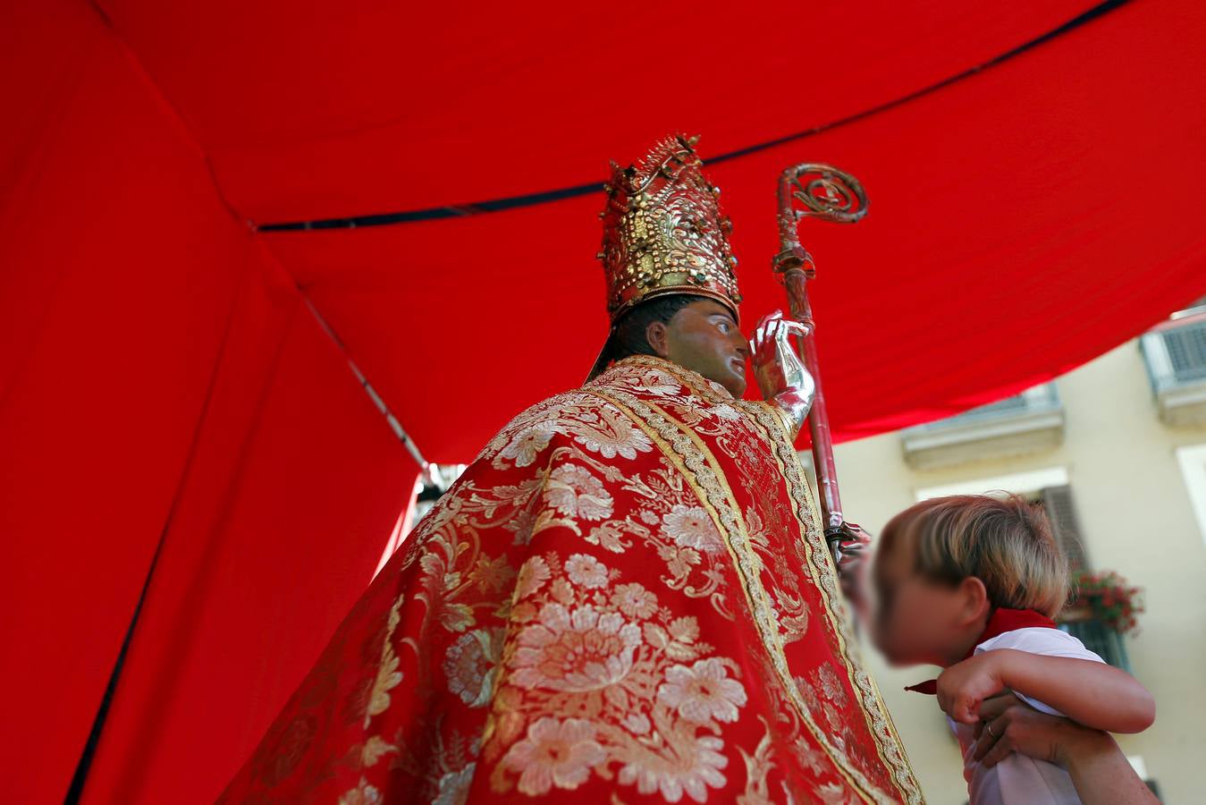 Un niño besa la estatua de San Fermín durante el festival de San Fermín en Pamplona