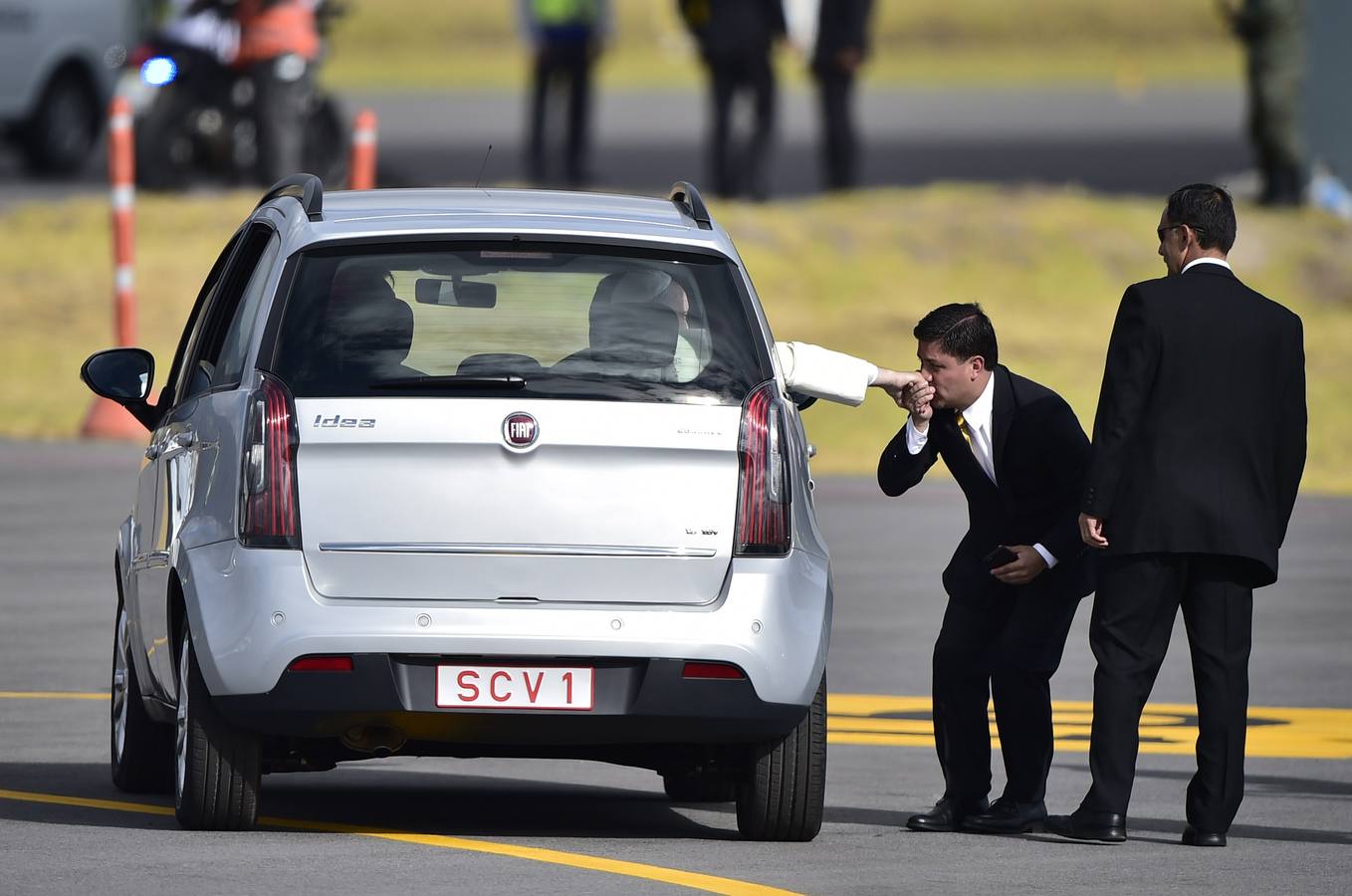 Un hombre besa el anillo de Francisco cuando sale a bordo de un coche pequeño en el aeropuerto internacional Mariscal Sucre, en Quito.