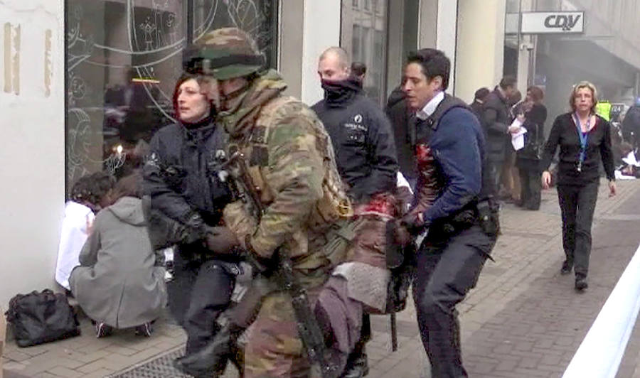 Las fuerzas de seguridad evacúan a uno de los heridos de la estación de metro de Maalbeek.