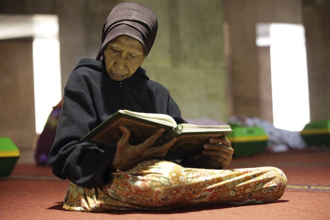 Una mujer musulmana lee el Corán mientras espera el final del ayuno en la mezquita Istiqlal en Yakarta, Indonesia