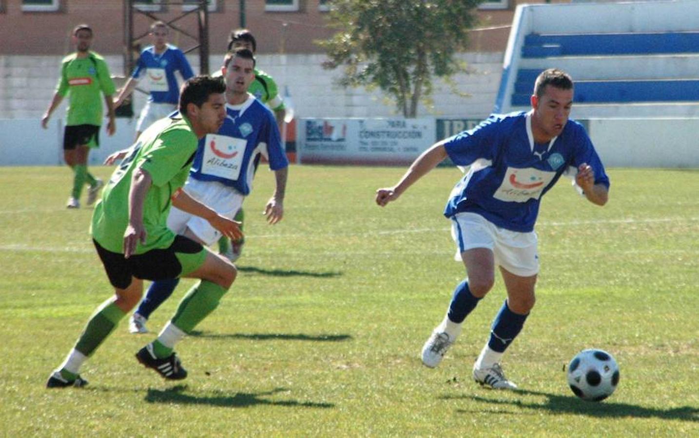 2009. Copito, jugador del Díter Zafra, se lleva un balón ante un jugador del Cerro de Reyes y su compañero.