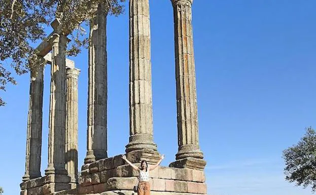 Una familia fotografía los mármoles de Talavera la Vieja.