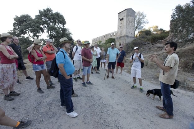 Los senderistas tras llegar a la mina de Valdeflores reciben explicaciones sobre el entorno. :: l. cordero