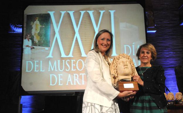 La directora del Museo Romano, Trinidad Nogales, hace entrega de uno de los Premios Genio Protector de la Colonia..