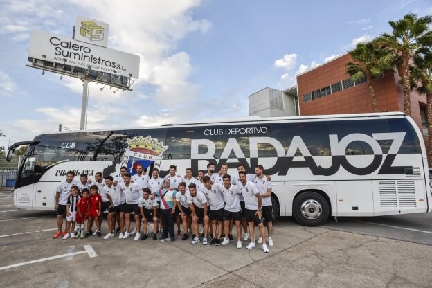 La plantilla del Badajoz posa frente al nuevo autobús del club en Calero Suministros. :: J. V. Arnelas