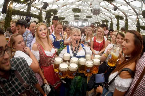 Una camarera del Oktoberfest se abre paso con un silbato mientras sujeta diez jarras de cerveza, lo máximo que se les permite coger para evitar problemas físicos. :: afp