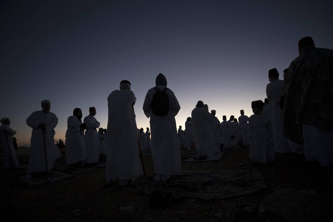 Miembros de la comunidad samaritana caminan hacia la cima del Monte Guerizín al amanecer en Nablus (Palestina), con motivo de la celebración del Sukot o fiesta de los tabernáculos.