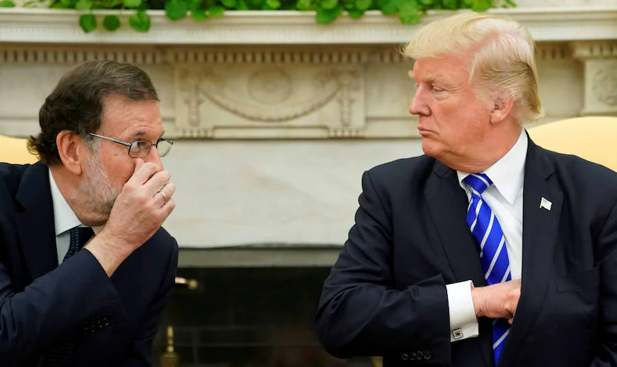 Mariano Rajoy se cubre la boca con la mano para dirigirse a Donald Trump en el Despacho Oval de la Casa Blanca ante numerosos cámaras y periodistas