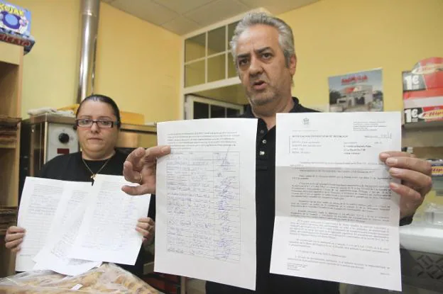 Consuelo González y Primitivo Montero muestran la multa recibida y las firmas recogidas. :: a. méndez 