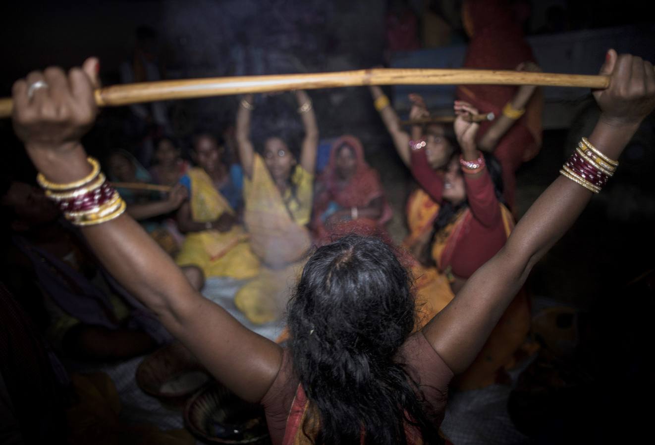 Un grupo de mujeres que creen haber sido poseídas por espíritus malignos danzan y cantan mantras en la víspera de una noche de luna llena, mientras se congregan para la celebración del "Festival de los fantasmas", en las orillas del río Kamala en el distrito de Danusha (Nepal), el 3 de noviembre de 2017. La celebración tiene siglos de tradición y tiene lugar anualmente en la noche de luna llena de noviembre. Miles de personas se congregan para llevar a cabo rituales de sanación conducidos por chamanes, en los que se "cura" a personas poseídas de espíritus malignos que acechan el porvenir de las familias.