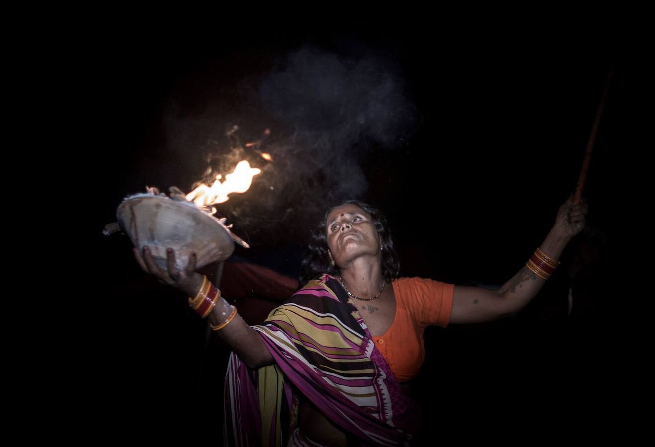 Un grupo de mujeres que creen haber sido poseídas por espíritus malignos danzan y cantan mantras en la víspera de una noche de luna llena, mientras se congregan para la celebración del "Festival de los fantasmas", en las orillas del río Kamala en el distrito de Danusha (Nepal), el 3 de noviembre de 2017. La celebración tiene siglos de tradición y tiene lugar anualmente en la noche de luna llena de noviembre. Miles de personas se congregan para llevar a cabo rituales de sanación conducidos por chamanes, en los que se "cura" a personas poseídas de espíritus malignos que acechan el porvenir de las familias.