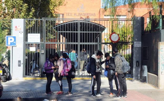 Entrada del IES Albarregas de Mérida con varios adolescentes en la puerta.