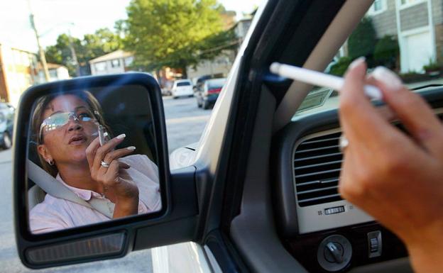 Una mujer fuma dentro del vehículo