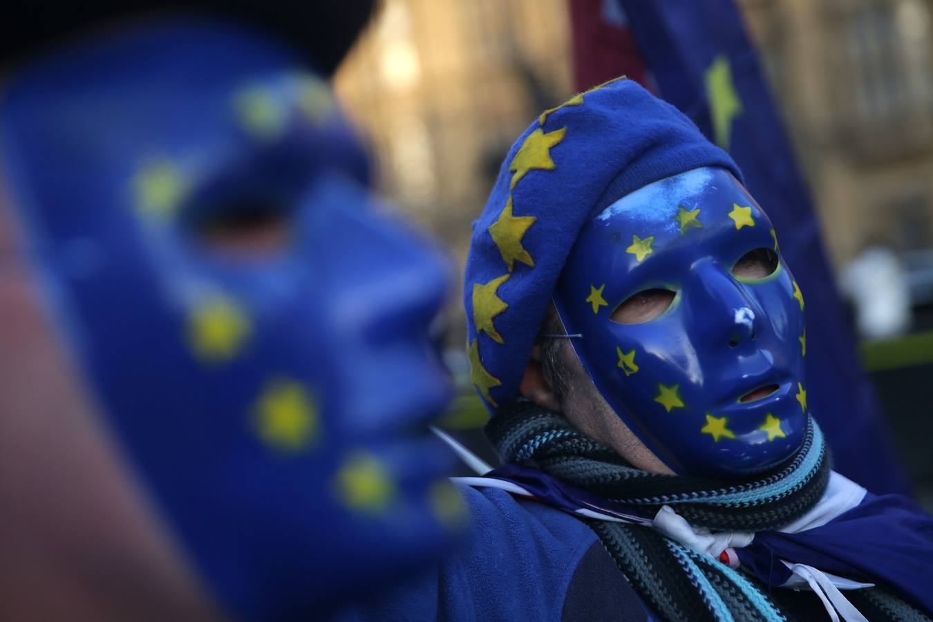 Los manifestantes pro-Unión Europea, (UE) y anti-Brexit usan máscaras con la bandera de la UE, ya que sostienen una bandera de la Unión fuera del Parlamento en el centro de Londres el 18 de diciembre de 2017. / AFP PHOTO / 