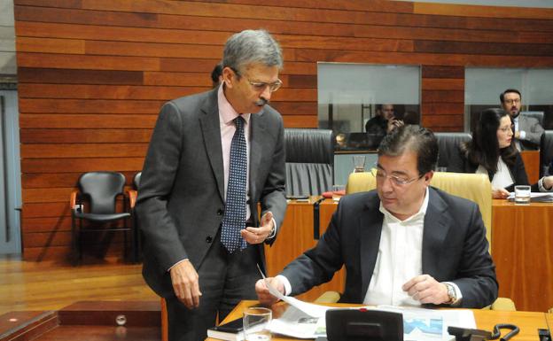 El consejero de Economía, Navarro, junto a Fernández Vara en el pleno de ayer en la Asamblea. 