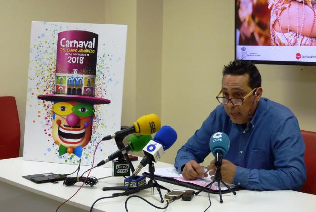 Alfredo Vizcaíno en la presentación del programa de actos acompañado por el cartel anunciador. :: MAM