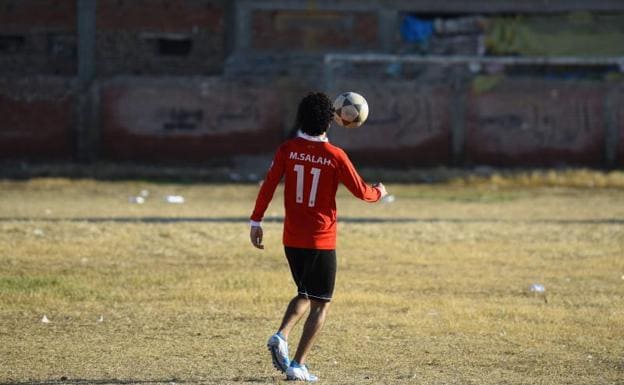 Un joven egipcio juega al fútbol en la localidad de Nagrig portando una camiseta de Salah. 