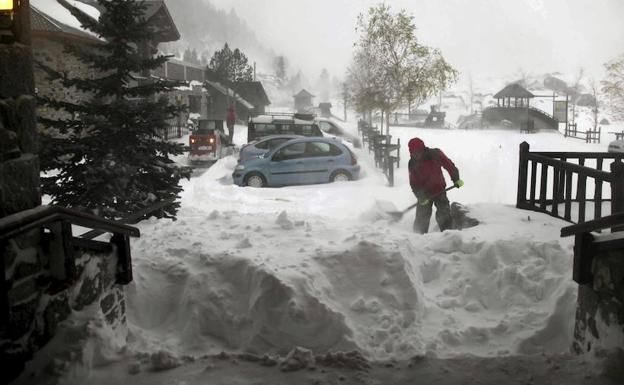 Un hombre retira nieve en la entrada de la estación de esquí de Llanos del Hospital, en el Pirineo de Huesca. 