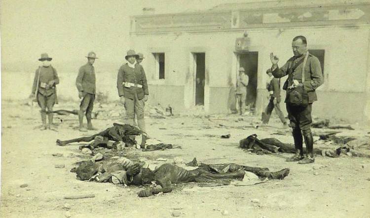 7-Postal de un capellán rezando ante muertos españoles tras el desastre de Monte Arruit, en agosto de 1921..