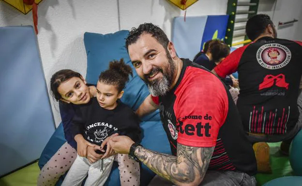 Francisco Santiago, en el gimnasio de la asociación con sus dos hijas, Daniela y Martina.