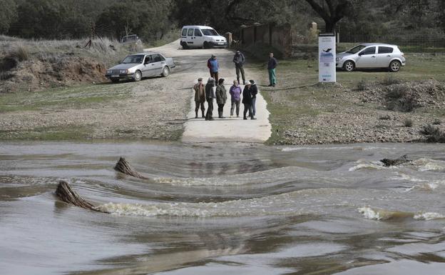 El río Salor desbordado sobre el puente de acceso hacia las parcelas de los propietarios que se quedaron aislados ayer.