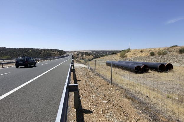 Tubos abandonados junto a la autovía a la altura del río Tajo desde hace años. :: HOY