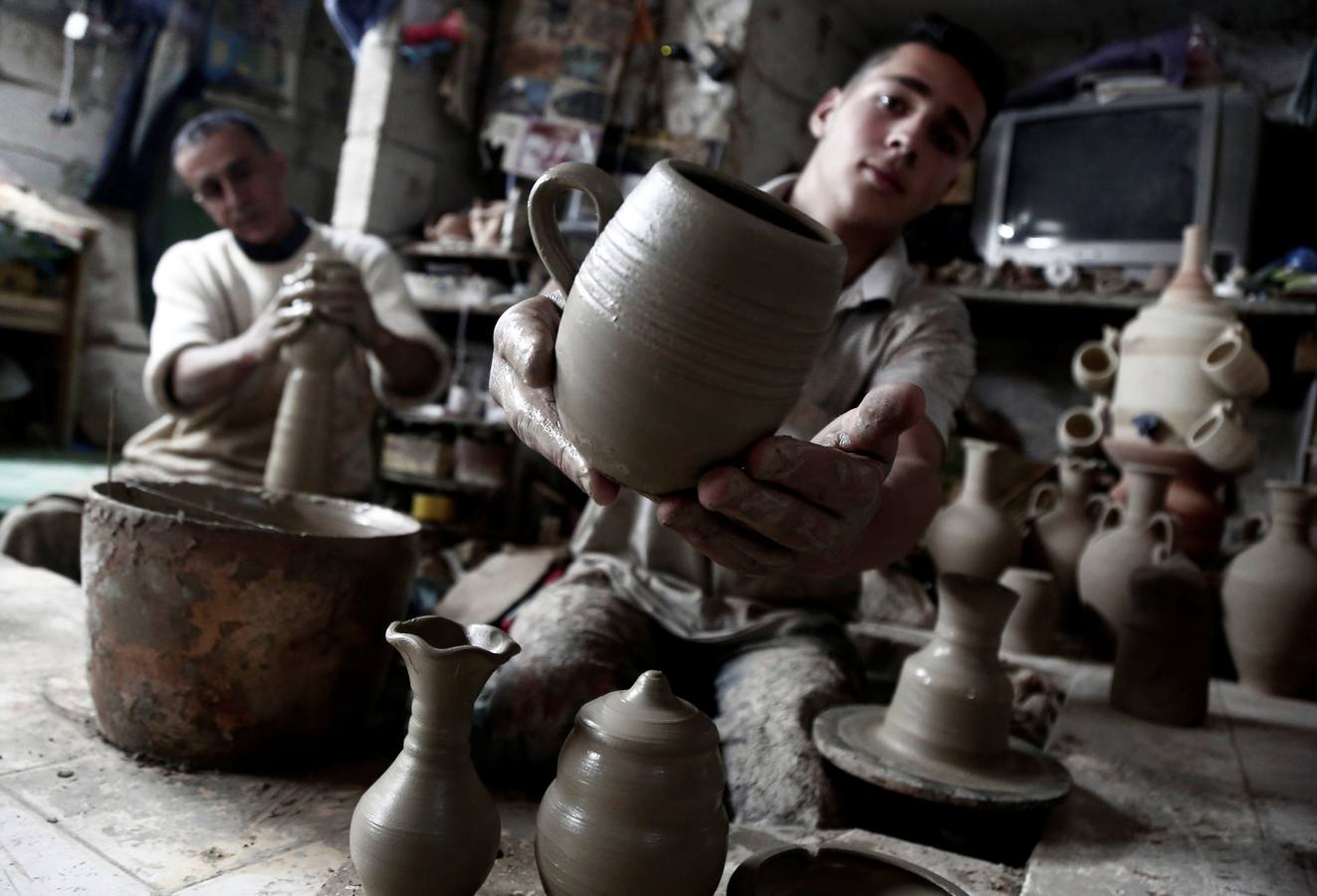 El palestino Jamal Fakhori y su hijo hacen vasijas de arcilla en su taller en la ciudad de Jaba, cerca de Jenin, en la ocupada Cisjordania