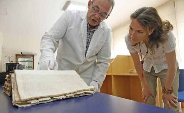 El archivero municipal, Fernando Jiménez Berrocal, explica a una visitante algunas de las vicisitudes del documento de ordenanzas medievales, en una imagen de archivo. 