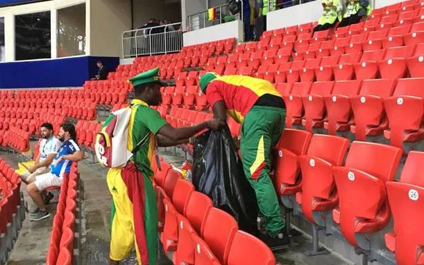 Los aficionados de Senegal, limpiando la grada. 