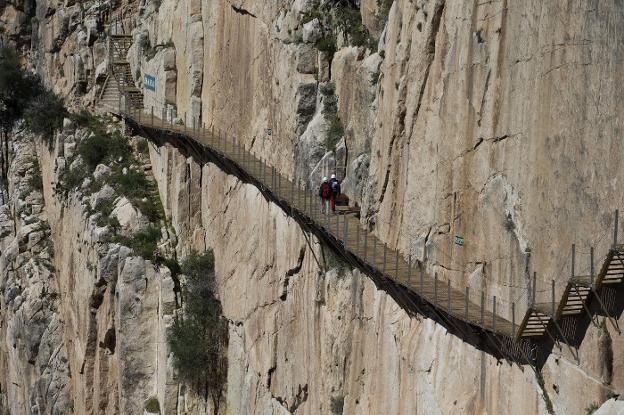 Una pareja de turistas recorre la imponente pasarela sobre las verticales paredes del Desfiladero de los Gaitanes. :: ñito salas