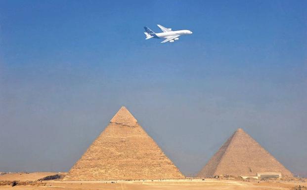 Un avión sobrevuela las pirámides de Guiza. 