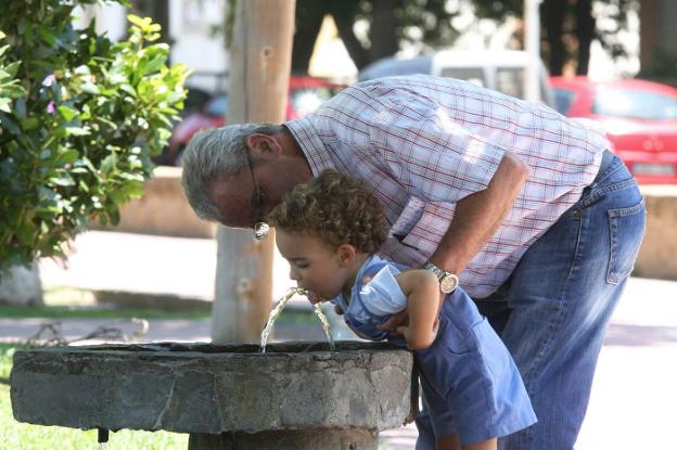 Adulto ayudando a beber a un niño. :: Hoy