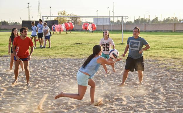 Jóvenes practica voley playa.