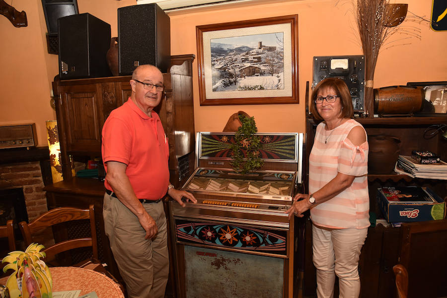 José Luis Gracia y Encarna Colmenar, junto a la máquina de música del bar 'El picaporte', en el centro histórico de la localidad cacereña.