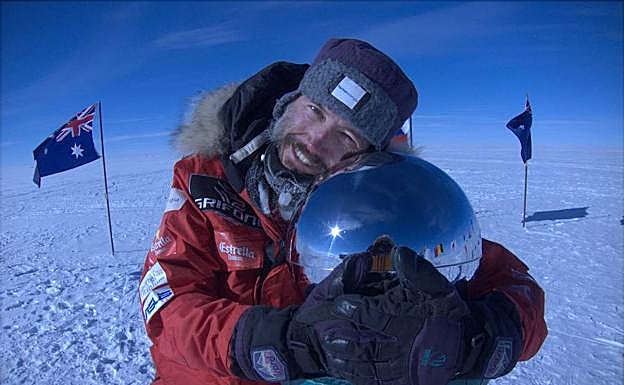 El aventurero se abraza a la base del polo Sur tras culminar su reto.