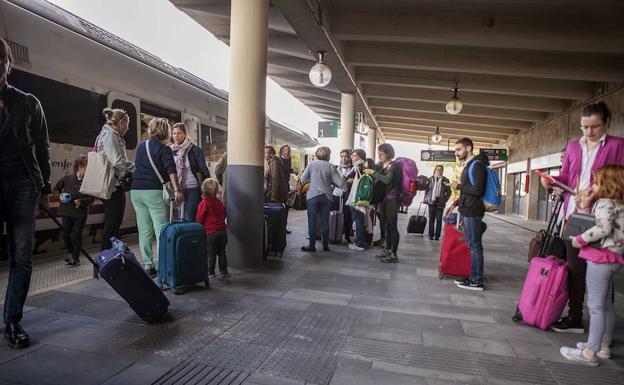 Algunos de los pasajeros esperando en la estación del Cáceres el tren que hizo este domingo el servicio del Talgo tras sufrir una avería y acumular 80 minutos de retraso. 