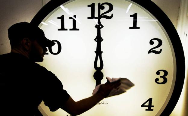 Un operario ajusta el reloj de manecillas de la Electric Time Company al cambio de horario. 