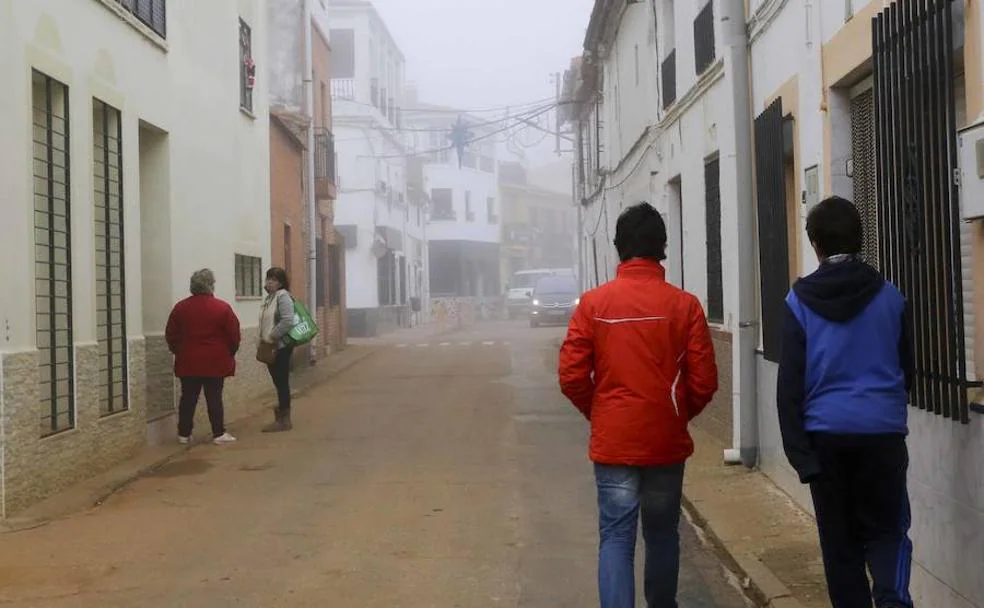 Dos menores caminan por una calle del centro de Castilblanco mientras dos mujeres conversan en este municipio de la comarca de La Siberia. :: 