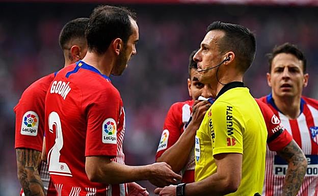 Los jugadores del Atlético hablan con Estrada Fernández tras la acción del penalti a Vinicius.