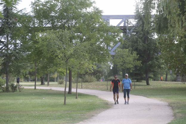 Dos personas pasean por la Isla en el tramo cercano al Puente de Hierro. :: j. m. romero