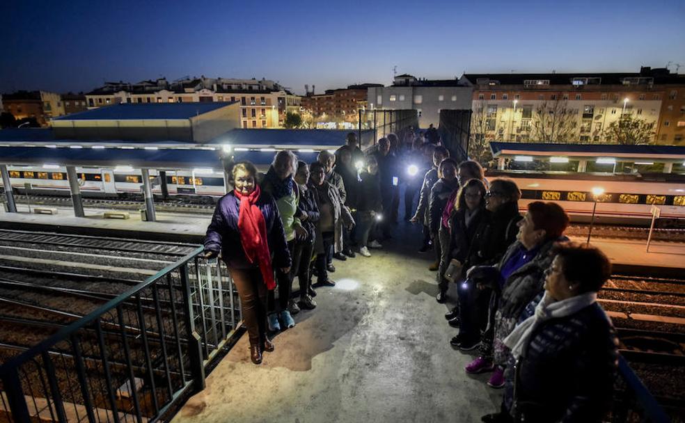 Un grupo de vecinos ilumina con linternas la plataforma que pasa sobre las vías del tren. :: J.V. ARNELAS