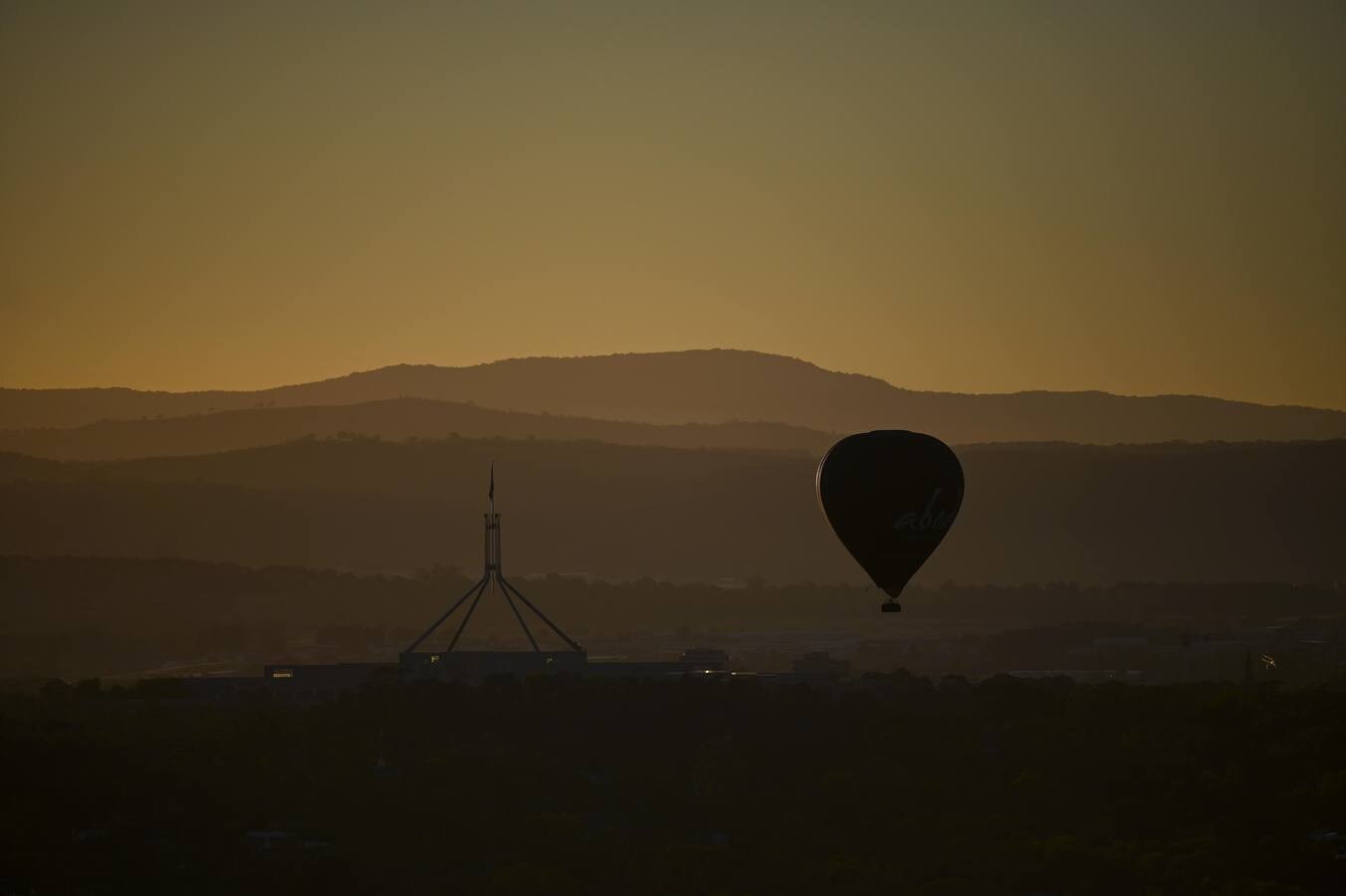 Observan cómo los globos aerostáticos se elevan sobre el lago Burley-Griffin durante el festival internacional de globos de Camberra, Australia. El festival es considerado como uno de los más grandes del mundo.