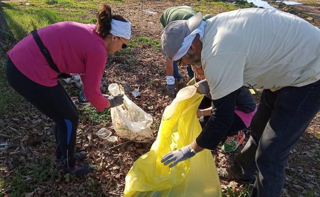 Voluntarios de Adenex durante la jornada de recogida de residuos en el entorno del Guadiana. ::