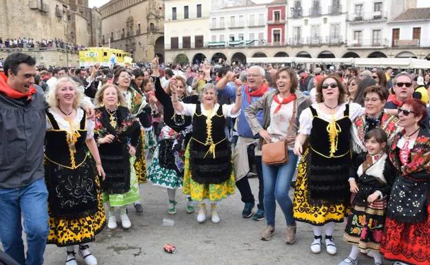 Vecinos, ataviados con el traje típico, bailando los temas tradicionales. 