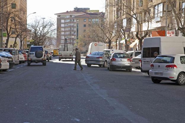 Coches aparcados en doble fila en una calle de Cáceres. :: HOY