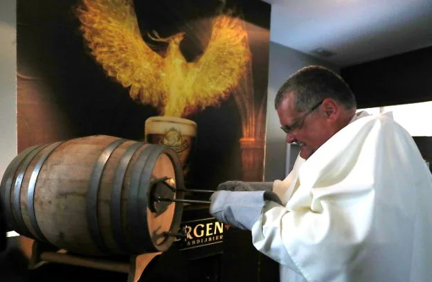El padre Karel marca un barril con el Ave Fénix, que ha sido elegido como símbolo de las cervezas de la abadía de Grimbergen. :: reuters