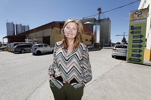 Mari Ángeles Muriel con la sede de la cooperativa Cooprado al fondo, en Casar de Cáceres.